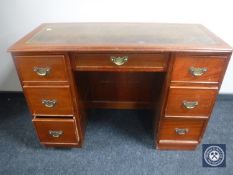 A Victorian mahogany child's kneehole writing desk fitted with seven drawers and tooled leather