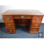 A Victorian mahogany child's kneehole writing desk fitted with seven drawers and tooled leather