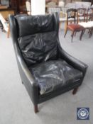 A mid 20th century black leather high back armchair
