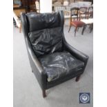 A mid 20th century black leather high back armchair