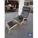 A high backed beech framed leather armchair and matching stool