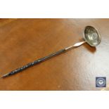 A Georgian silver toddy ladle, inset with a George II six pence dated 1743.