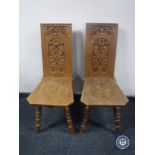 A pair of carved oak hall chairs