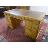 A Ducal Pine twin pedestal writing desk with tooled leather top fitted eight drawers