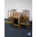 A late 20th century teak drop leaf table together with four chairs