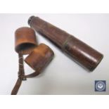 An early 20th century lacquered brass telescope in brown leather sleeve