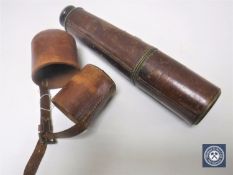 An early 20th century lacquered brass telescope in brown leather sleeve