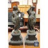 A pair of patinated bronze figures of torch bearers,