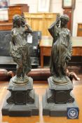 A pair of patinated bronze figures of torch bearers,
