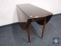 An antique mahogany drop leaf table