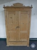 An antique pine double door cupboard fitted drawer beneath