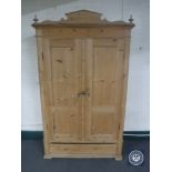 An antique pine double door cupboard fitted drawer beneath