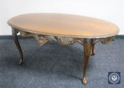An oval walnut coffee table