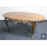 An oval walnut coffee table