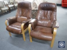 A pair of brown leather beech framed adjustable armchairs