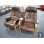 A pair of brown leather beech framed adjustable armchairs