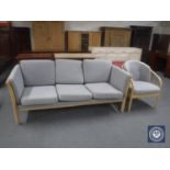 A blonde oak framed three seater settee and armchair with grey cushions