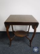 A twentieth century oak flap sided occasional table on shaped legs