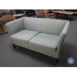 A mid 20th century two seater settee in green fabric