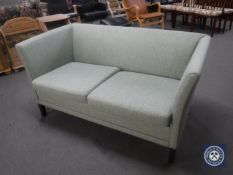 A mid 20th century two seater settee in green fabric