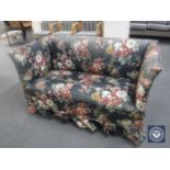 An early 20th century two seater settee in floral fabric and two scatter cushions