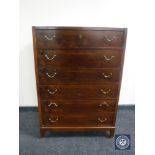 A mid twentieth century teak six drawer chest with brass drop handles