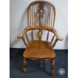 An antique elm kitchen armchair