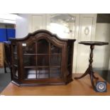 A mahogany glazed door wall mounted curio cabinet and a wine table