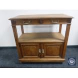 An antique oak serving stand fitted with double cabinet beneath and two drawers