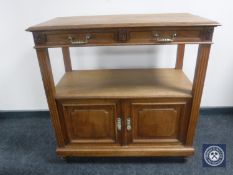 An antique oak serving stand fitted with double cabinet beneath and two drawers