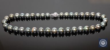 A 14ct white gold pearl and diamond necklace, thirty-seven black/peacock-green Tahitian pearls,