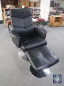 A black leather swivel armchair with footstool on chrome base