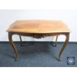 A shaped walnut table on cabriole legs