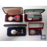 A collection of four medals on ribbons - Imperial service medal, long service defence medal,