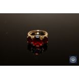 A 9ct gold ring set with three garnet type stones, size N.
