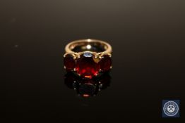A 9ct gold ring set with three garnet type stones, size N.