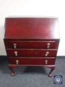 A stained 20th century bureau on claw and ball feet