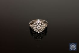 A white gold diamond cluster ring, the central diamond weighing approximately 0.