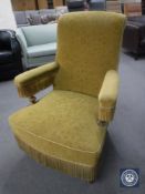An antique armchair in gold brocade fabric