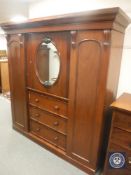 A Victorian mahogany compactum wardrobe with mirrored door,