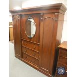 A Victorian mahogany compactum wardrobe with mirrored door,