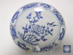 A nineteenth century Chinese blue and white plate decorated with song bird on flowers, diameter 27.