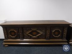 An early 20th century carved oak three door sideboard