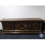 An early 20th century carved oak three door sideboard