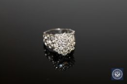 An 18ct white gold diamond cluster ring, on honeycomb shank,