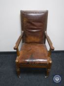 An antique mahogany framed armchair upholstered in brown leather