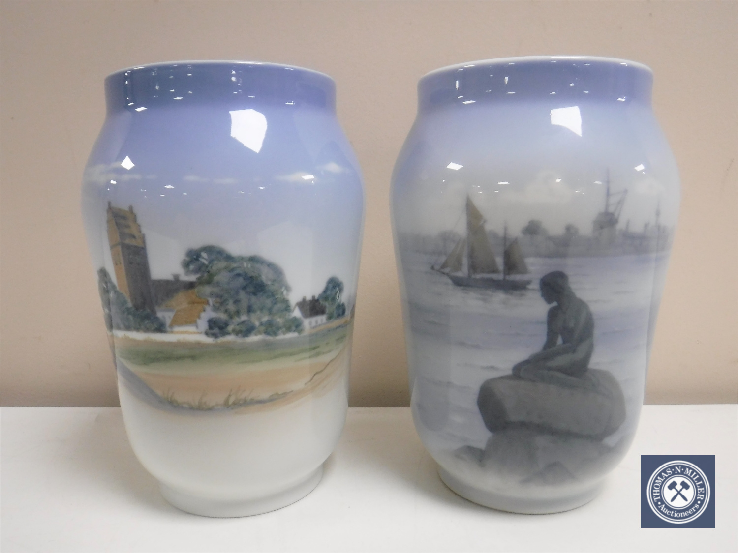 Two Royal Copenhagen vases depicting a figure on rock and a rural landscape,