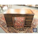 A Georgian style mahogany pedestal desk with brown tooled leather top,