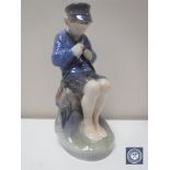 A Royal Copenhagen figure of a boy whittling a stick,