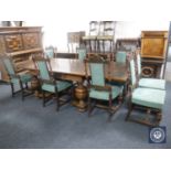 An early 20th century oak pull out dining table and eight high back carved oak chairs (one damaged)